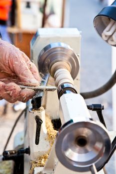 Old worker hands at lathe