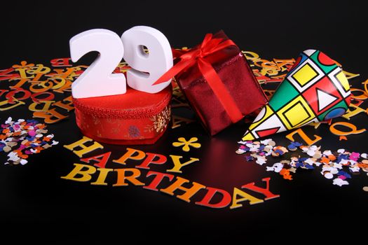 Happy birthday on a black background  and a red heart  and white caracters and confetti
