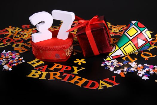 Happy birthday on a black background  and a red heart  and white caracters and confetti