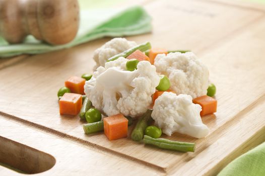Vegetable mix with cauliflower, carrot, peas and kidney bean on the wooden board