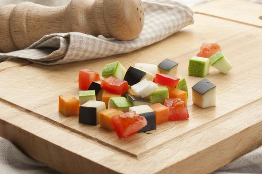 Vegetables mix on the wooden board with salt shaker and napkin
