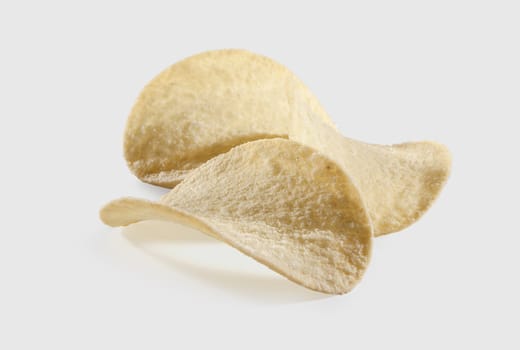 Three potato chips on the gray background
