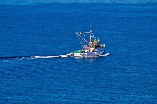 Fishing trawler on open blue water aerial view