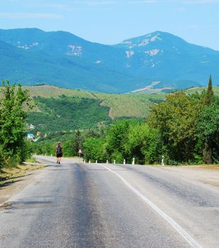 The lonely traveller. Mountain road to city