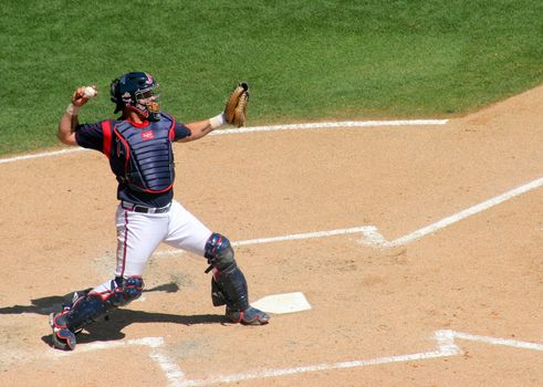 The catcher throwing the ball at a baseball game