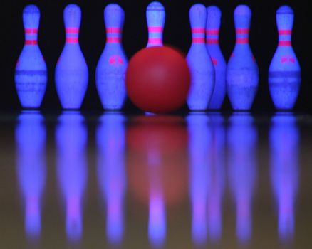 A bowling ball just about to hit the pins.