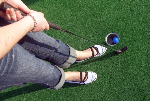 Putting a ball at an adventure golf.