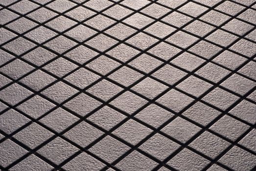 Criss-crossed design of diamond shaped street tiling.