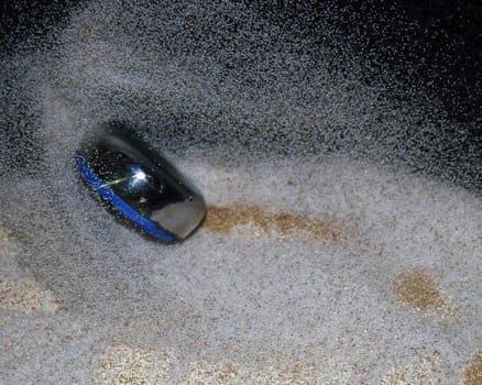 This is a shuffleboard fly going through the sand.