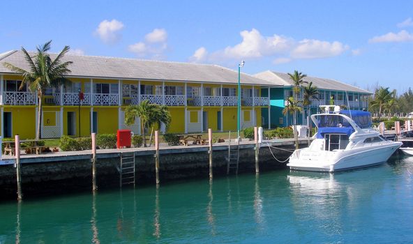 Colorful waterfront houses in the Bahamas and a boat.