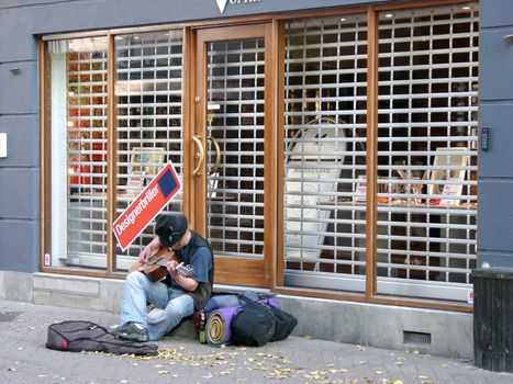 Street musician playng guitar in Odense (Denmark), October 2005.