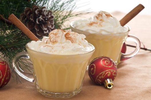 Festive drink of eggnog with whipped cream and cinnamon.