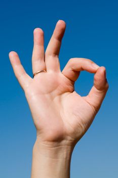 hand signal. Human hand on a blue sky