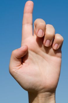 one. Human hand on a blue sky