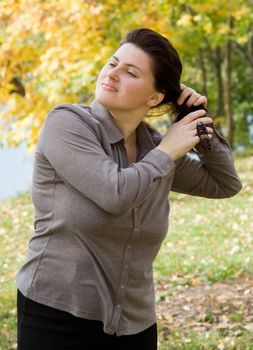 The beautiful young woman corrects a hairdress.