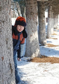 Winter. The smiling little boy against trees.