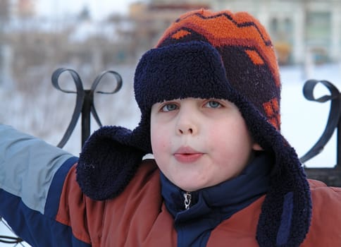 Whistle. The little boy in a winter cap.