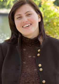The smiling beautiful woman against the river