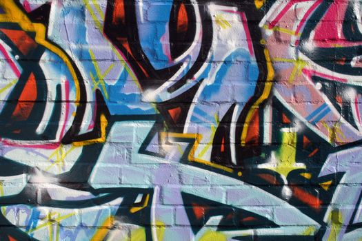 Detail of a very colourful illegal graffiti on a bricked wall in a backyard in Germany.