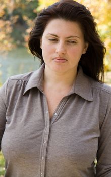 The beautiful young woman against the river
