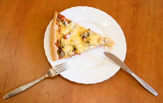 Pizza piece on a white plate with plug and knife