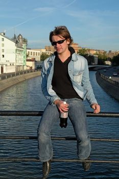 Cool dude with a bottle against the river
