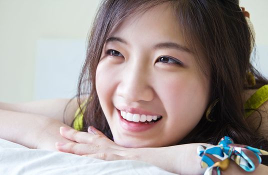 Asian woman smiling on the bed