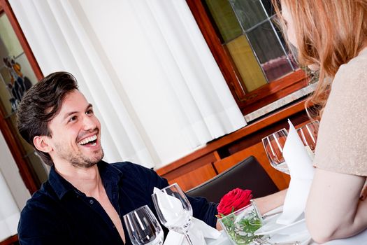 happy smiling couple in restaurant for dinner sitting talking drinking