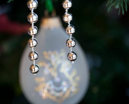 Christmas tree decorated with silver and white ribbons and ornaments in family home