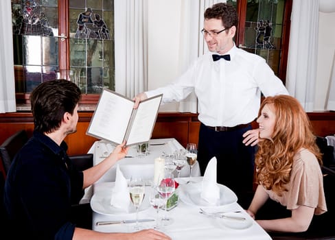 man and woman in restaurant waiter bring card and order food