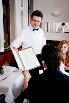 man and woman in restaurant waiter bring card and order food