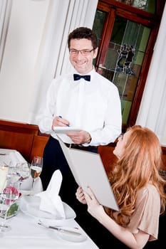 man and woman in restaurant waiter bring card and order food