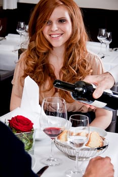 man and woman in restaurant for dinner drinking red wine and smiling