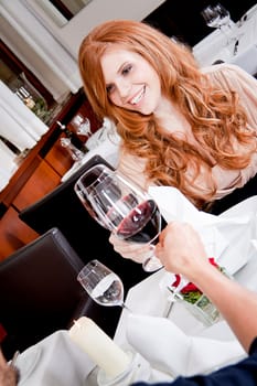 man and woman in restaurant for dinner drinking red wine and smiling