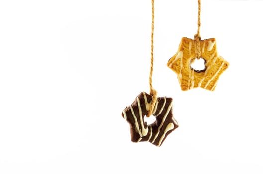 Shortbread cookies with milk and chocolate glaze hanging on a rope on a white background