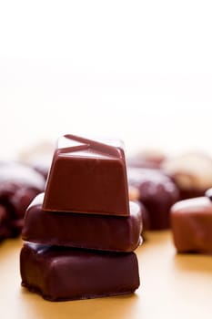 collection of different chocolate pralines truffels on golden brown background macro