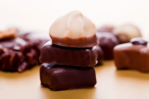 collection of different chocolate pralines truffels on golden brown background macro