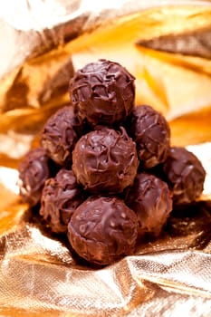 collection of different chocolate pralines truffels on golden brown background macro
