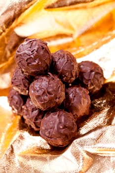 collection of different chocolate pralines truffels on golden brown background macro