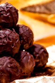 collection of different chocolate pralines truffels on golden brown background macro