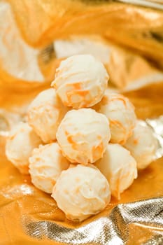 collection of different chocolate pralines truffels on golden brown background macro