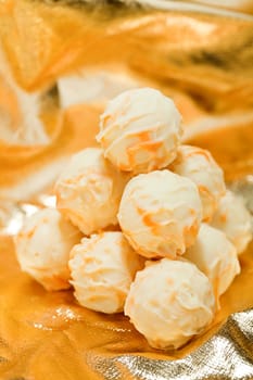 collection of different chocolate pralines truffels on golden brown background macro