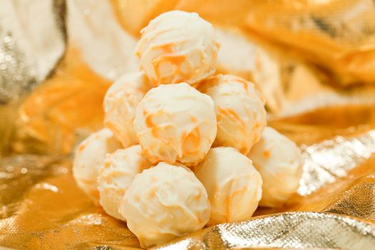 collection of different chocolate pralines truffels on golden brown background macro