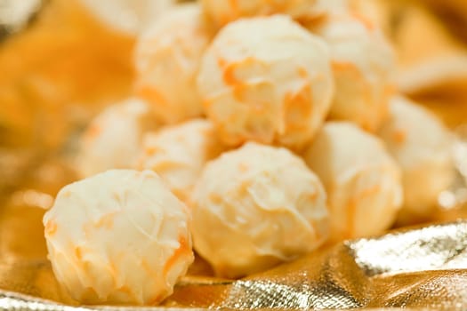 collection of different chocolate pralines truffels on golden brown background macro