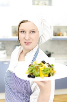 Pretty cook chief holding salad