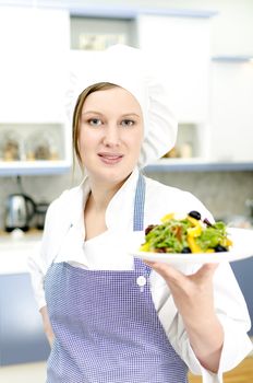 Pretty cook chief holding salad