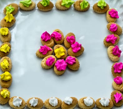 An arrangement of colorful icing topped cookies in white plate