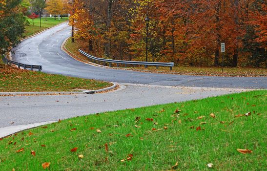 Two roads intersecting in the colorful woods on a fall day
