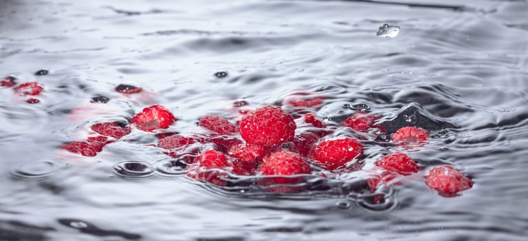 Red Raspberries Dropped into Water with Splash, closeup