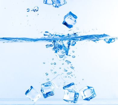 Ice Cubes Dropped into Water with Splash on white